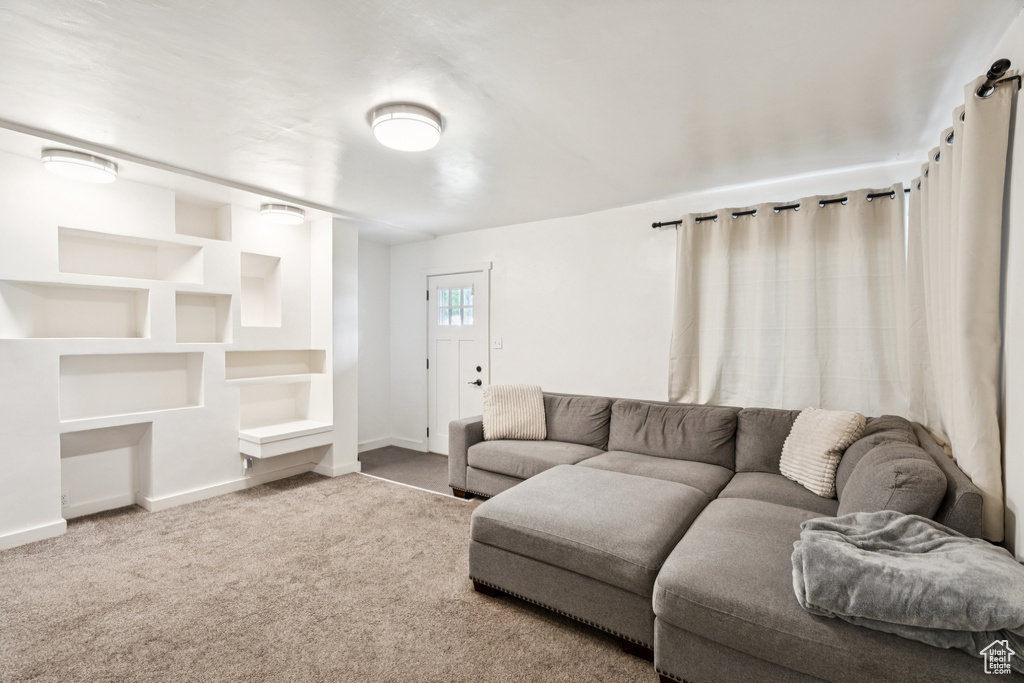 Living area with carpet flooring and built in shelves