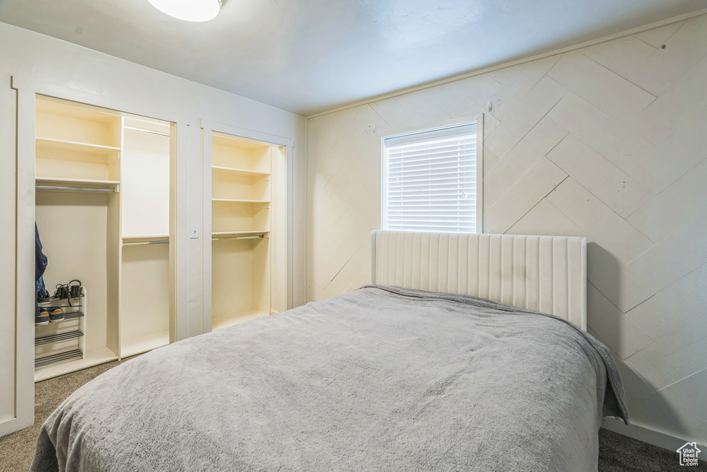 Carpeted bedroom featuring multiple closets