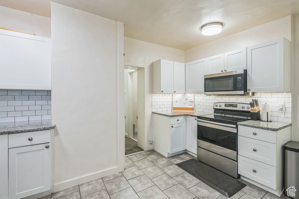 Kitchen with stainless steel appliances, tasteful backsplash, and light stone countertops