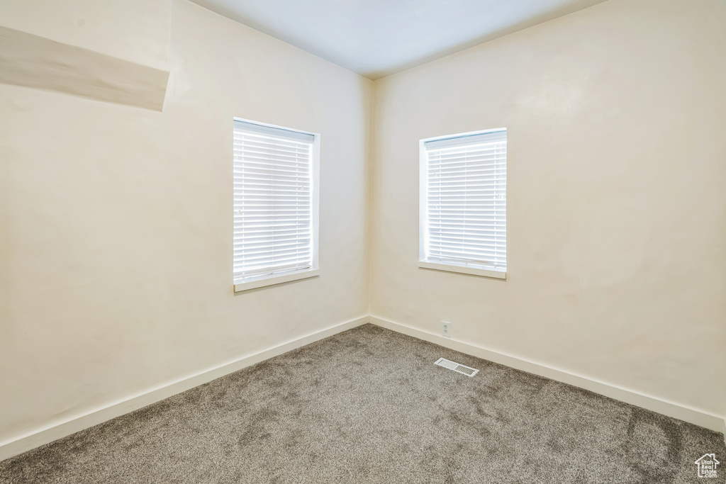 Spare room featuring carpet flooring and baseboards