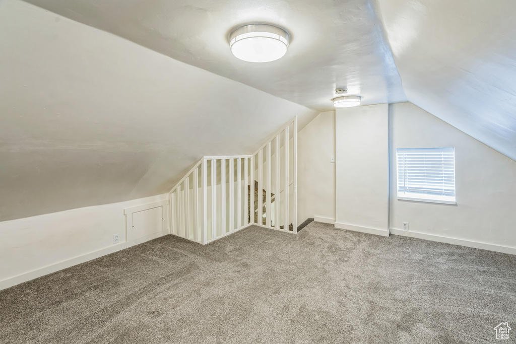 Additional living space with lofted ceiling and carpet floors
