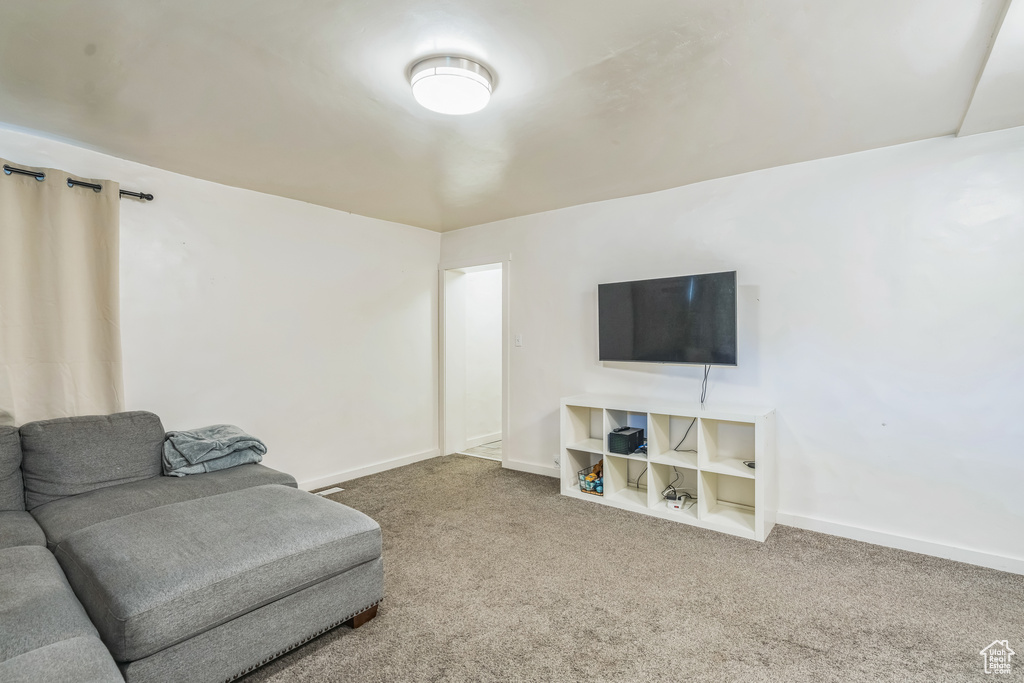 Carpeted living room featuring baseboards