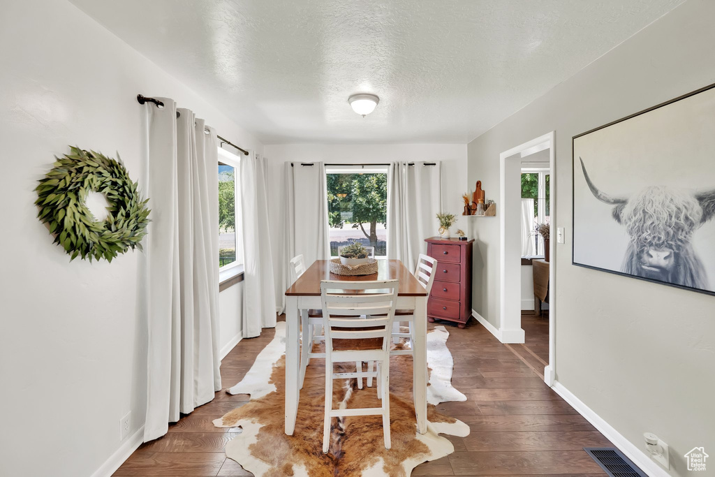 Dining room featuring a textured ceiling and dark wood-style floors