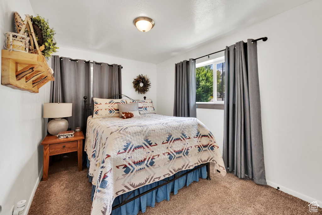 Bedroom featuring carpet flooring and baseboards