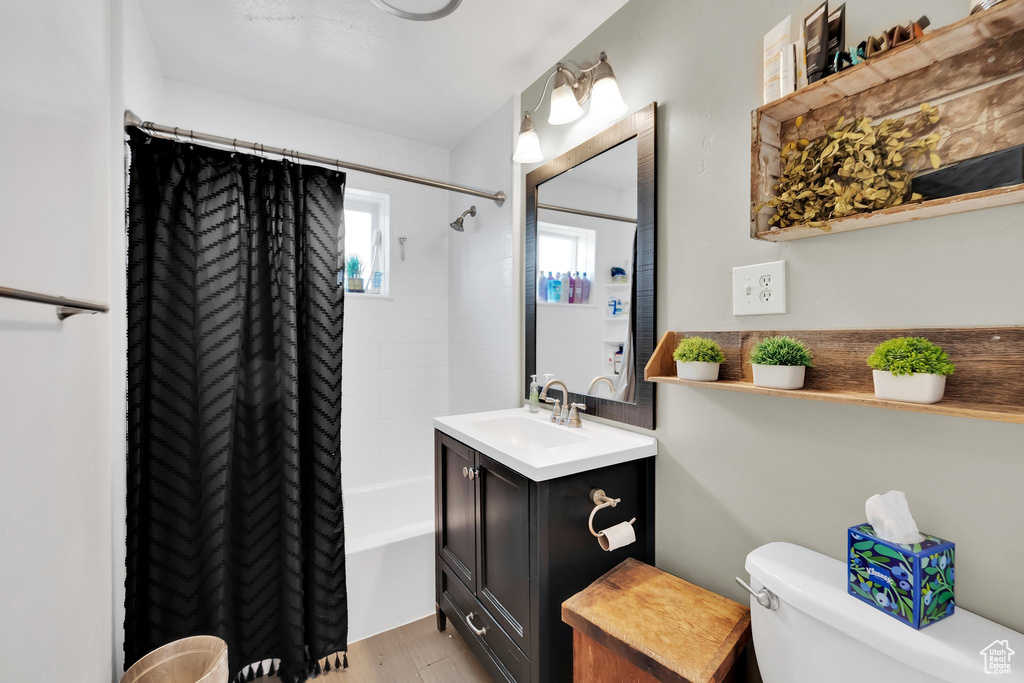 Bathroom with vanity, shower / tub combo with curtain, and wood finished floors