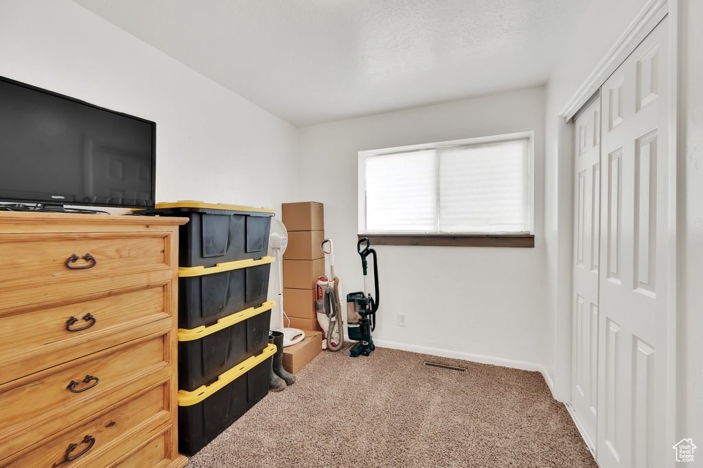 Carpeted bedroom featuring a closet and baseboards