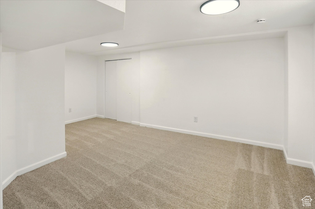 Unfurnished room with carpet floors and a smoke detector
