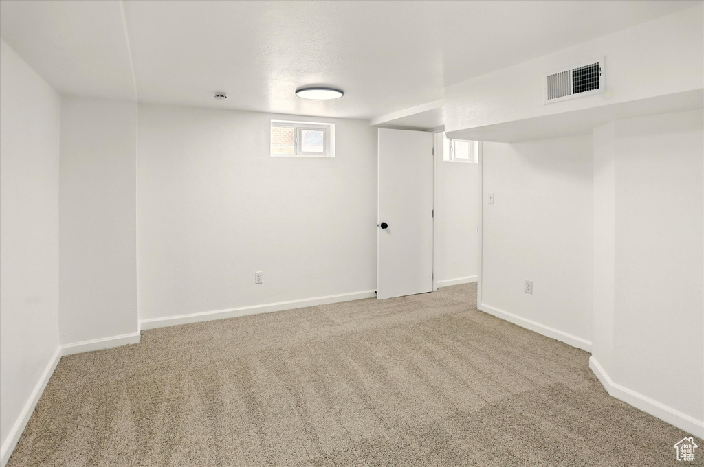 Basement featuring carpet flooring and baseboards