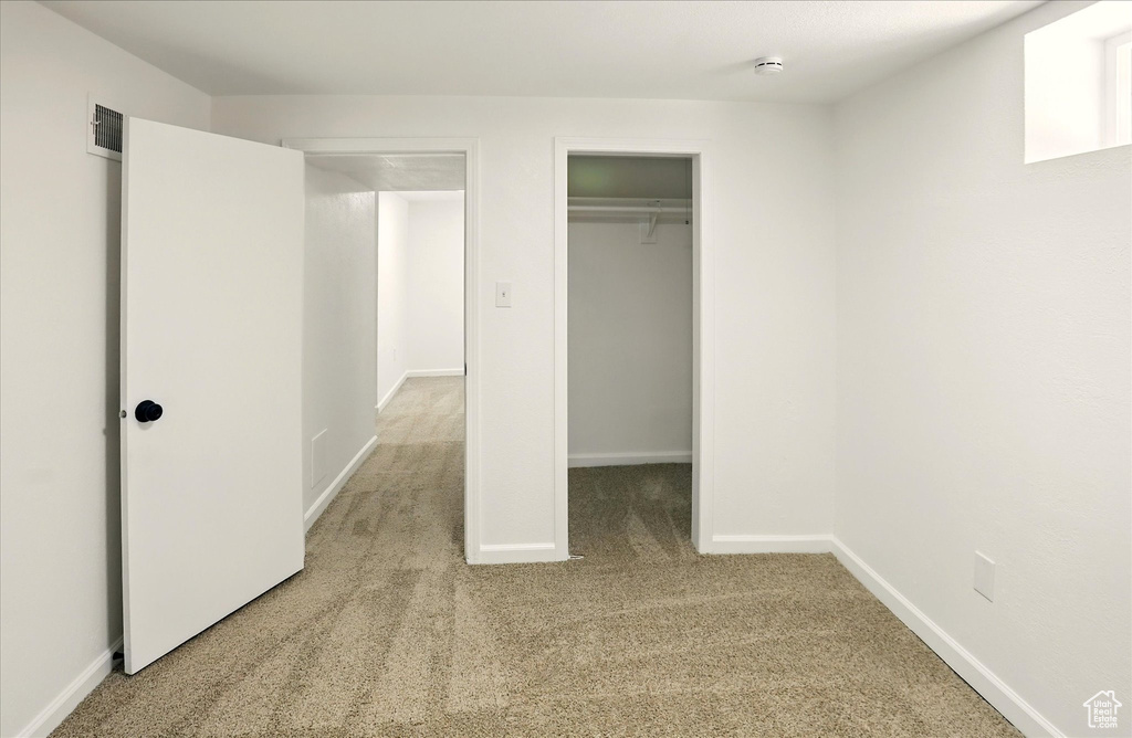 Unfurnished bedroom featuring light colored carpet and a closet
