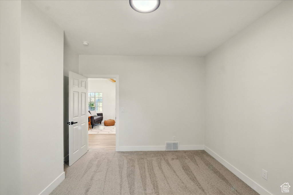 Carpeted spare room with baseboards and a smoke detector