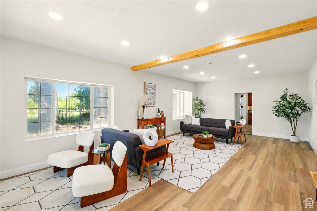 Living room with recessed lighting, light wood-style flooring, and beam ceiling