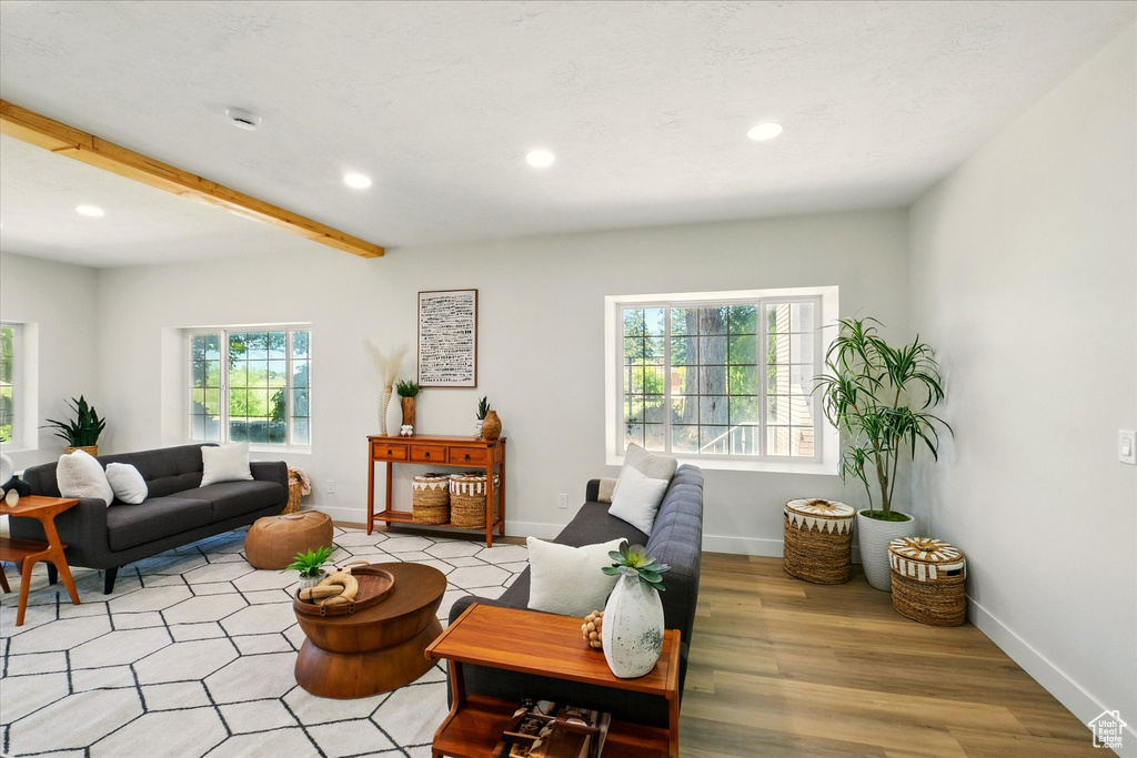 Living room with recessed lighting, light wood finished floors, and beam ceiling