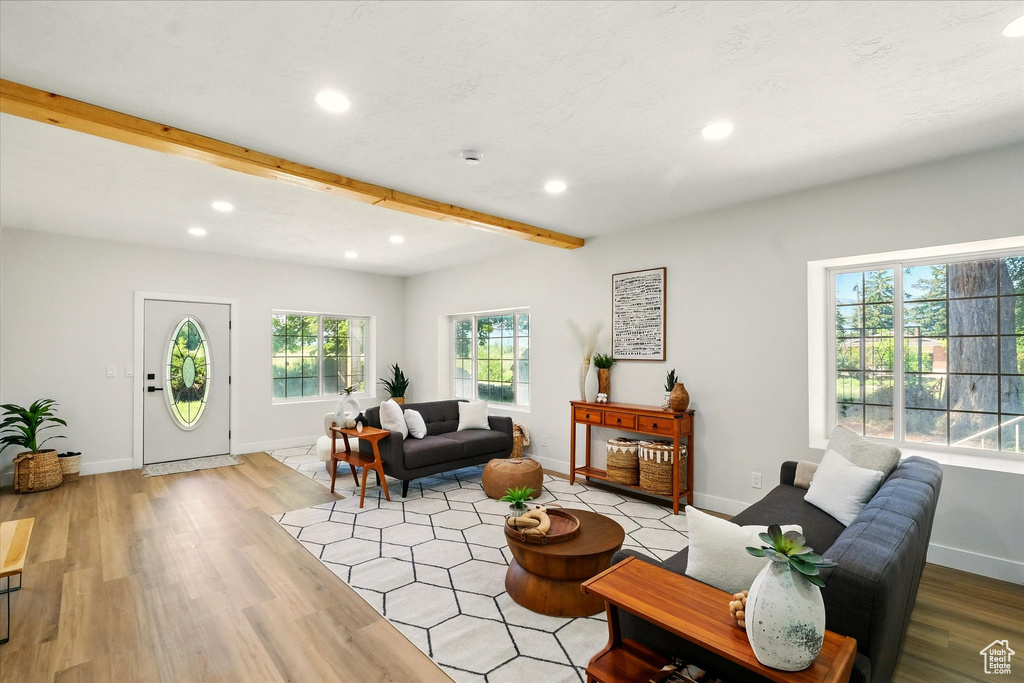 Living room with recessed lighting, beamed ceiling, and light wood-style floors