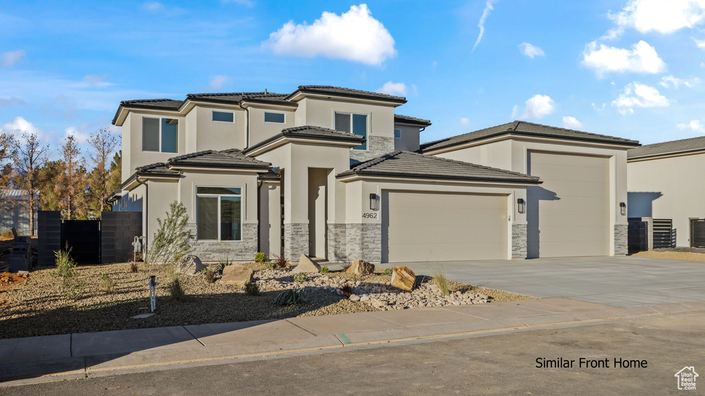 Prairie-style house featuring stone siding, an attached garage, concrete driveway, and stucco siding