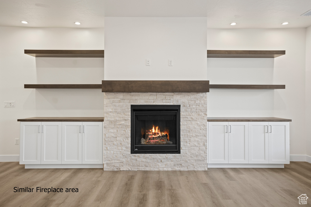 Unfurnished living room with light wood-style floors, a fireplace, and recessed lighting