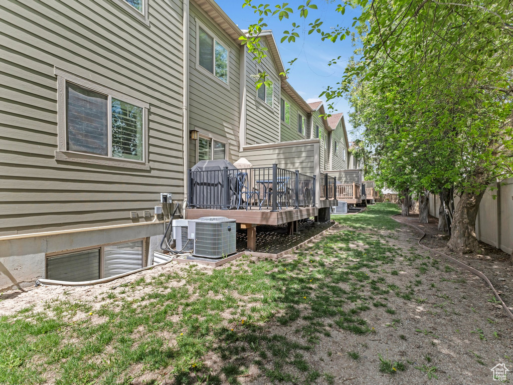 View of yard featuring central AC and a deck