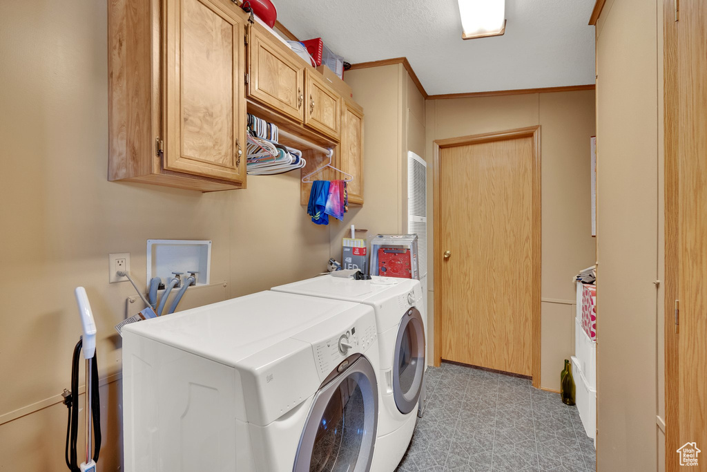 Washroom featuring cabinet space and independent washer and dryer