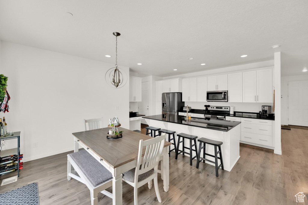 Dining room featuring light wood-style flooring, recessed lighting, and a chandelier
