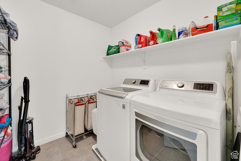 Laundry room with washer and dryer and light tile patterned flooring
