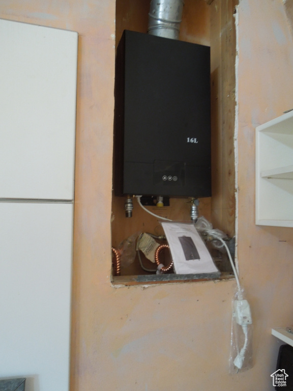 Detailed view of water heater and freestanding refrigerator