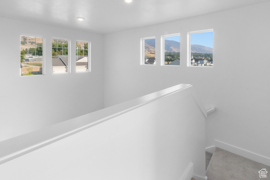 Hall featuring an upstairs landing, carpet flooring, plenty of natural light, and recessed lighting