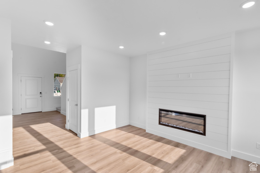 Unfurnished living room with recessed lighting, a fireplace, and light wood-style floors