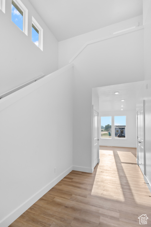 Corridor with healthy amount of natural light and light wood-style flooring