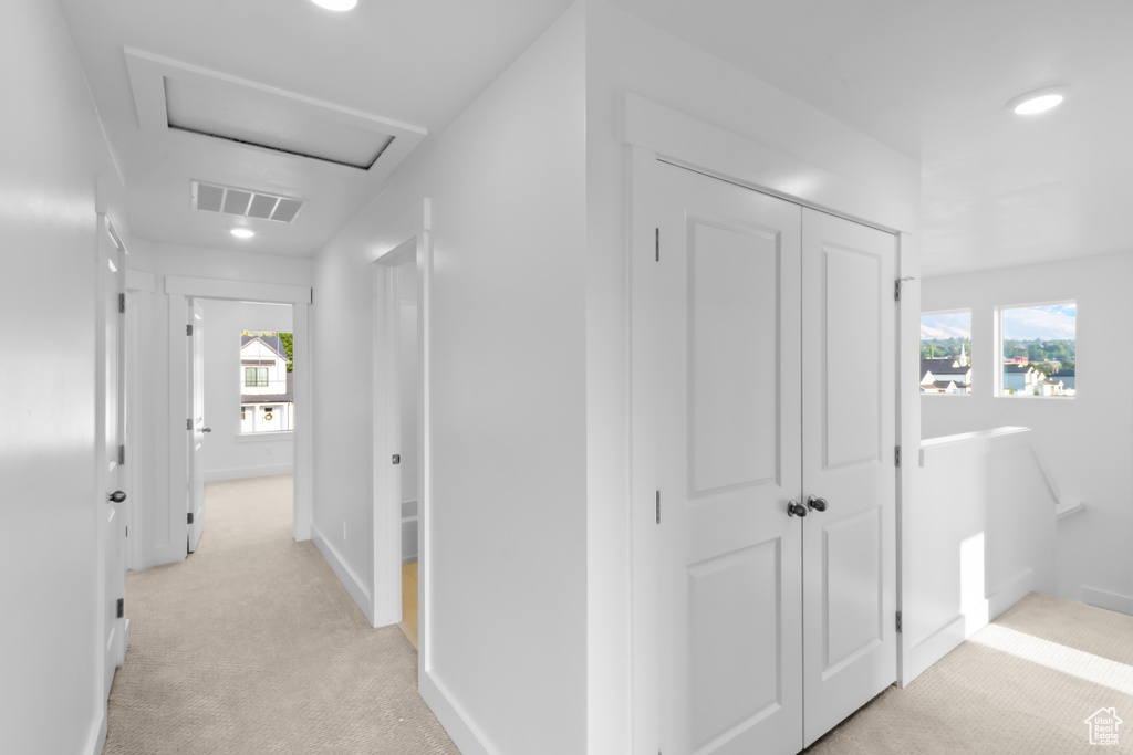 Corridor with light carpet, plenty of natural light, attic access, and recessed lighting