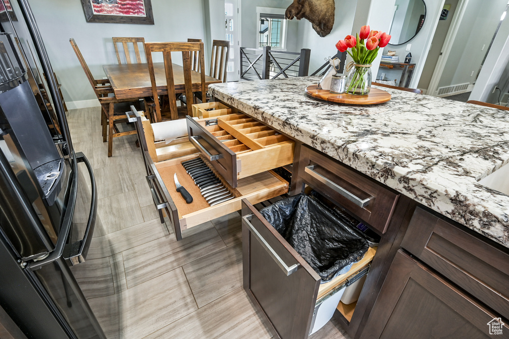 Kitchen with freestanding refrigerator and light stone countertops