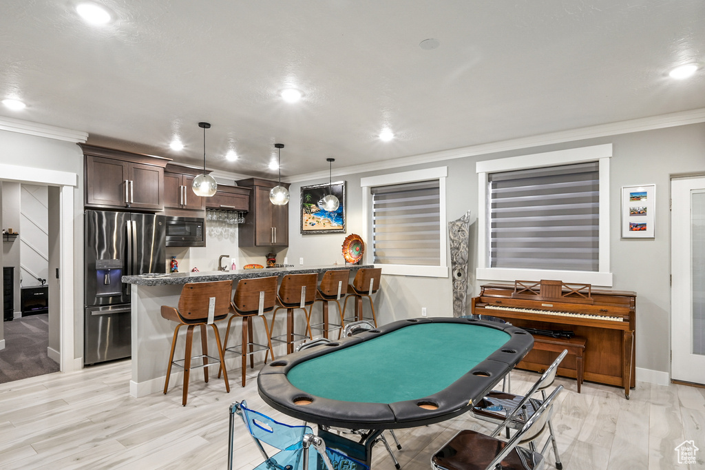 Rec room with crown molding, wet bar, recessed lighting, and light wood finished floors