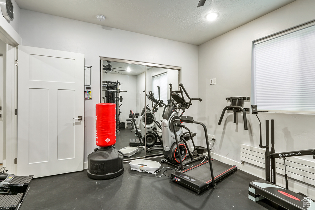 Exercise room featuring a ceiling fan and a textured ceiling