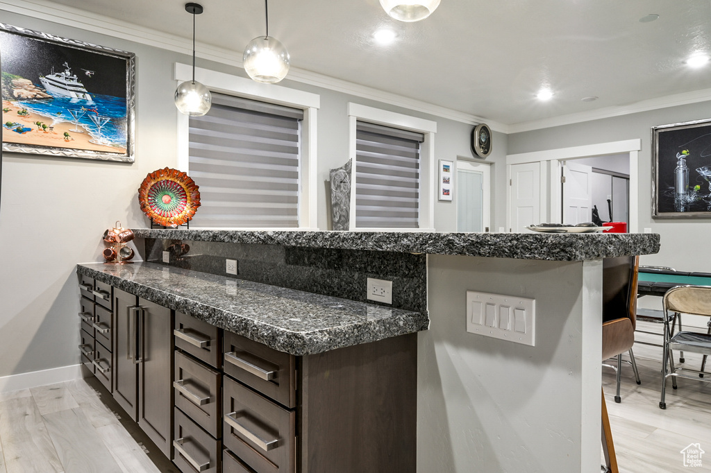Bar featuring crown molding, hanging light fixtures, and recessed lighting
