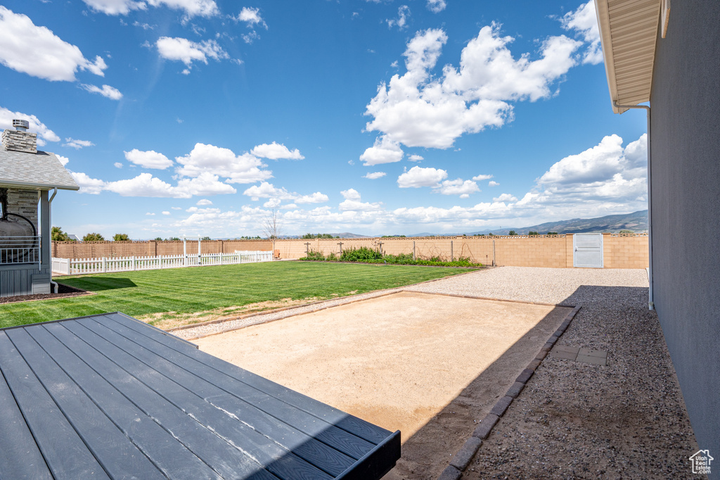 Fenced backyard featuring a patio area and a wooden deck