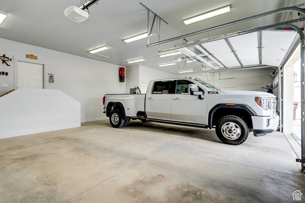 Garage with a garage door opener and baseboards