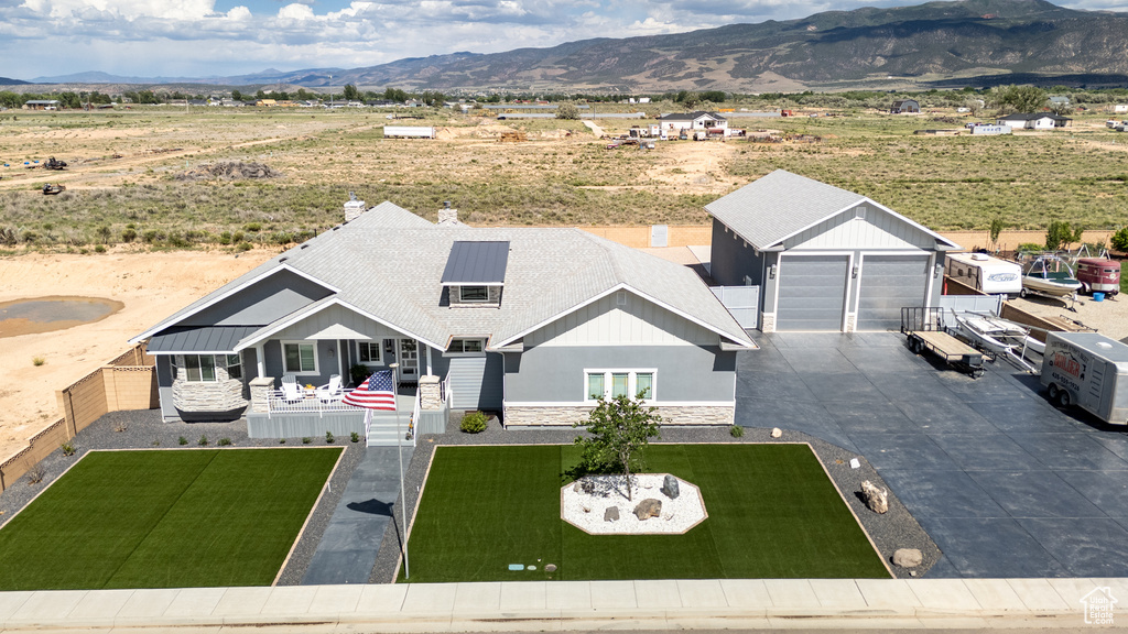 View of front of house featuring a mountain view and a front yard