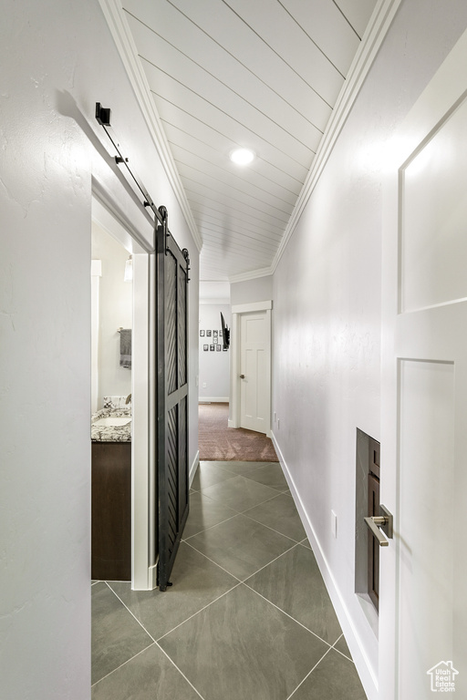 Hallway with a barn door and crown molding