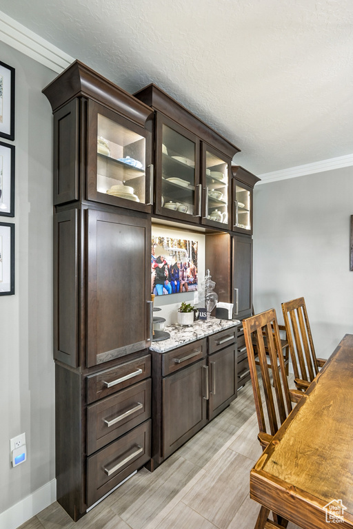 Bar featuring crown molding and light wood finished floors