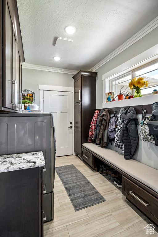 Mudroom featuring ornamental molding, washing machine and clothes dryer, and a textured ceiling