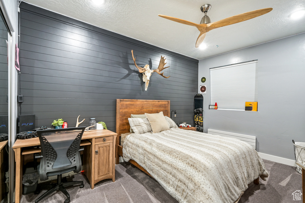 Bedroom featuring light carpet, a desk, and a ceiling fan