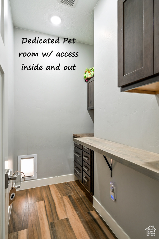 Washroom with dark wood-type flooring and baseboards
