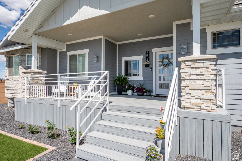 View of exterior entry with a porch and stone siding