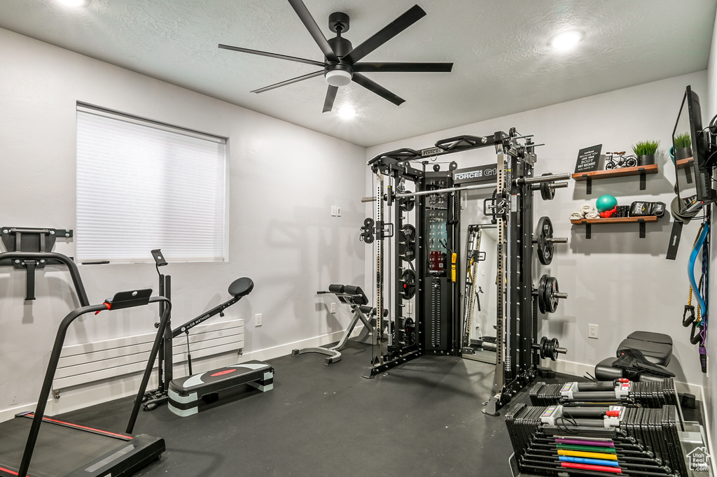Exercise room featuring a ceiling fan and a textured ceiling