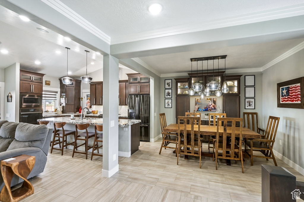 Dining room with ornamental molding and baseboards