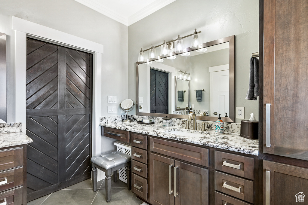 Bathroom featuring vanity, ornamental molding, and tile patterned floors