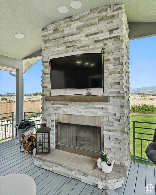 Wooden deck with an outdoor stone fireplace