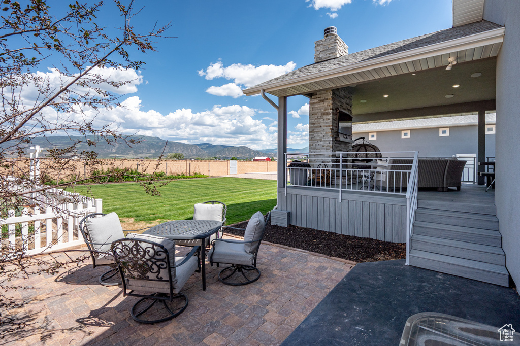 View of patio with outdoor dining space and a deck with mountain view