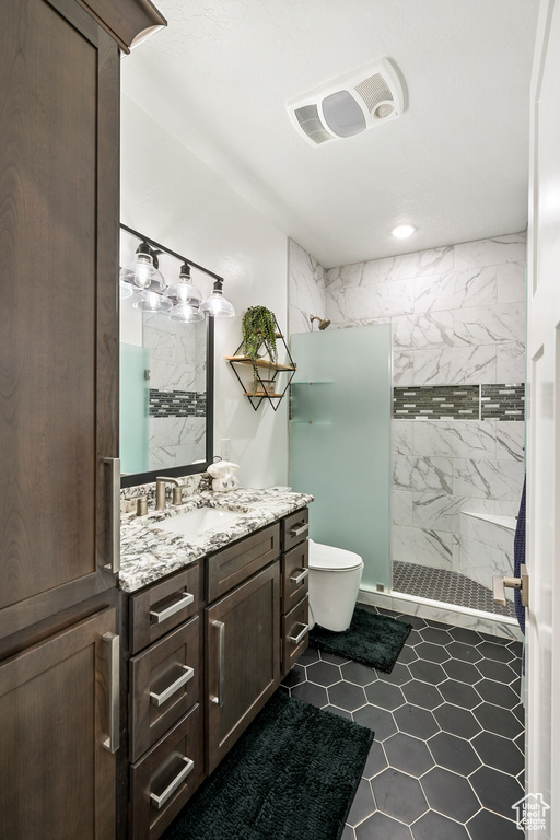 Bathroom with a shower stall, vanity, tile patterned flooring, and recessed lighting