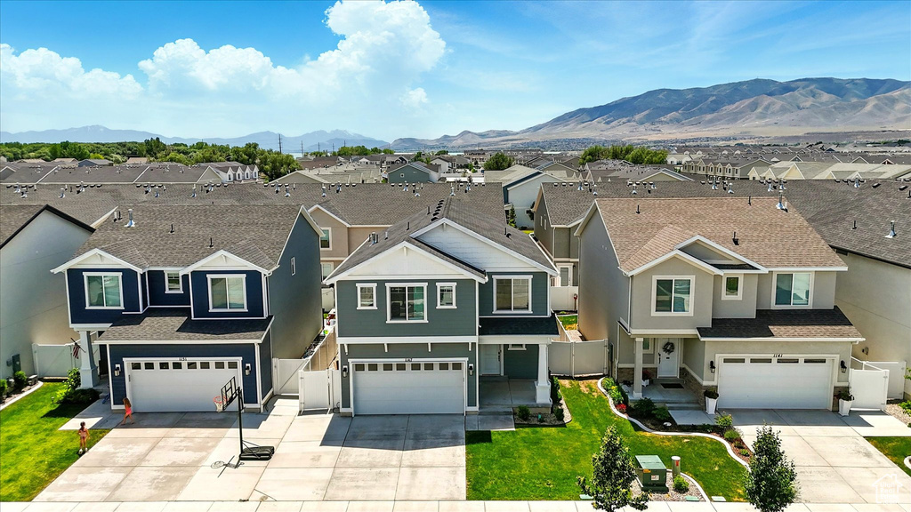Traditional-style home with a residential view, an attached garage, concrete driveway, and a mountain view