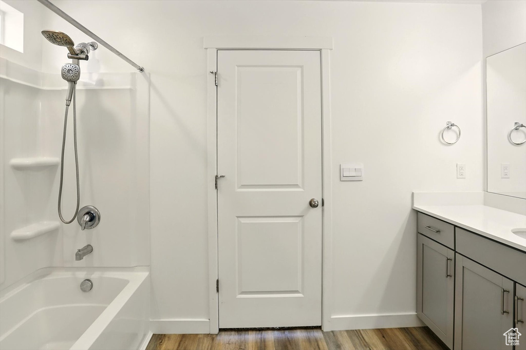 Bathroom with vanity, wood finished floors, and shower / bathtub combination