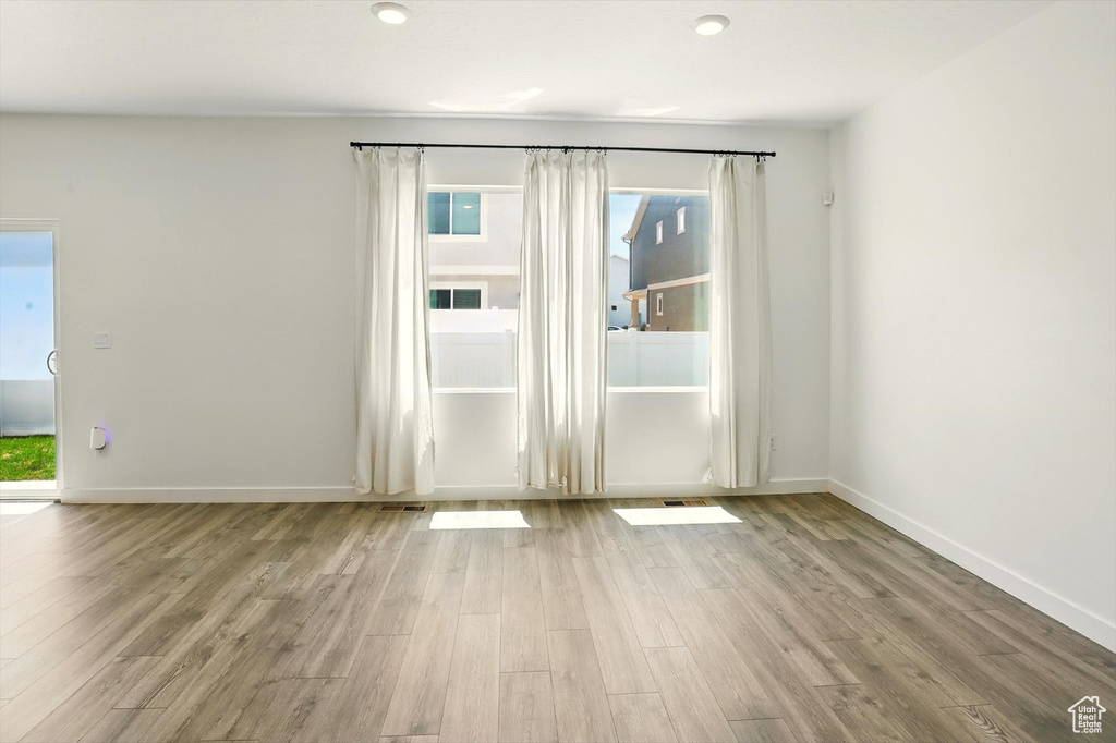 Spare room featuring wood finished floors and healthy amount of natural light